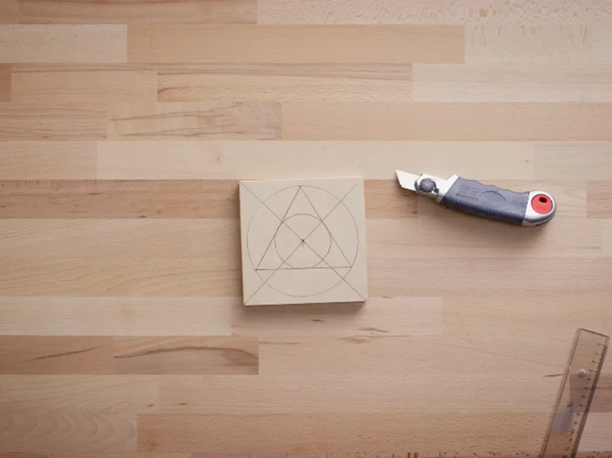 Holzplatte mit eingezeichneten Formen und Cuttermesser